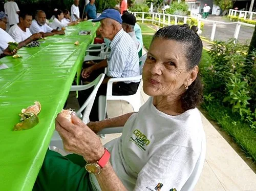 Adultos mayores compartiendo en una mesa verde