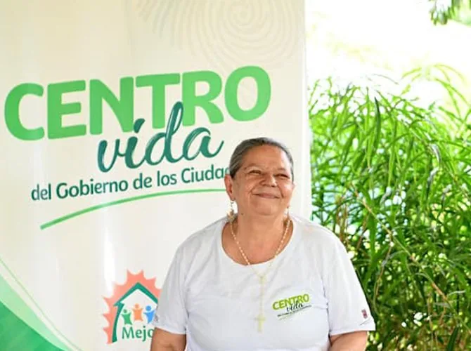 Mujer mayor junto al cartel de Centro Vida